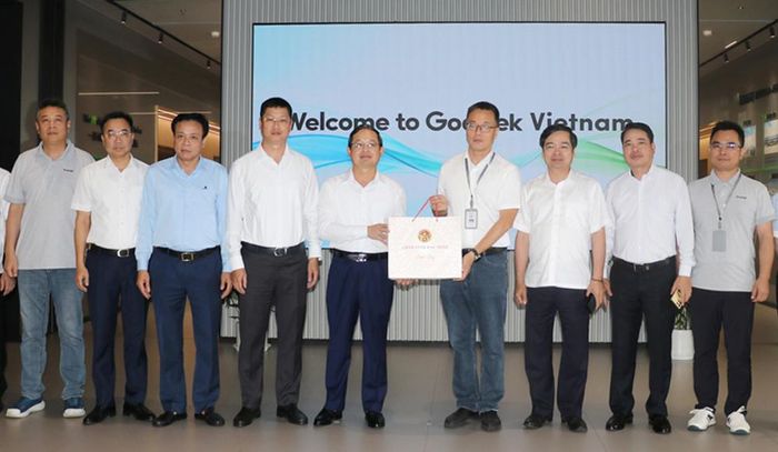  Đồng chí Phạm Hoàng Sơn và Trần Huy Phương tặng quà, chụp ảnh lưu niệm với tập thể lãnh đạo Công ty trách nhiệm hữu hạn Công nghệ Thông minh Goertek Vina. 
