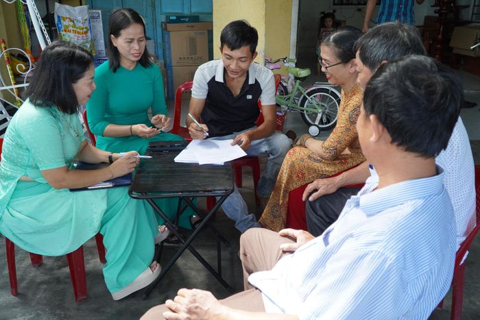Tổ công tác tổ dân phố Mỹ Thạch Đông đến nhà dân lấy ý kiến cử tri đại diện hộ gia đình về dự thảo đề án sắp xếp tổ dân phố. Ảnh: N.ĐOAN
