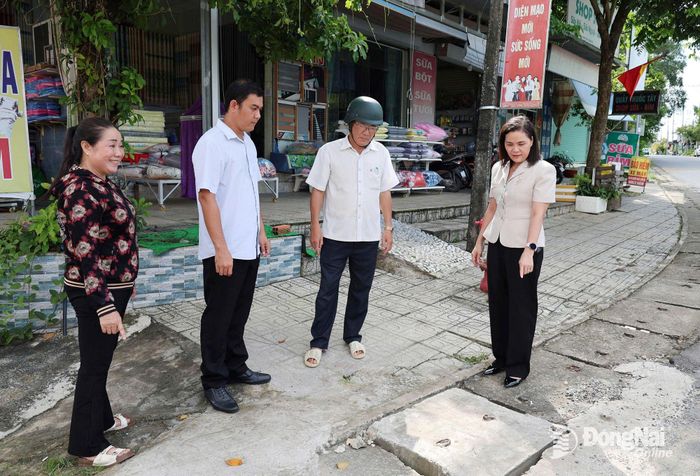 Phó Chủ tịch HĐND xã Đại Phước Nguyễn Thị Ngọc Mai cùng cử tri và cán bộ ấp Thị Cầu khảo sát khu vực nắp cống đã được sửa chữa sau ý kiến phản ánh của cử tri. Ảnh: Hồ Thảo