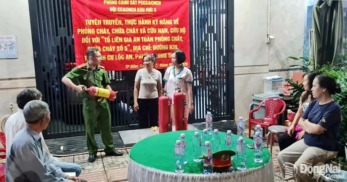Cán bộ Đội CC và CNCH khu vực 3 hướng dẫn người dân sử dụng bình chữa cháy xách tay.