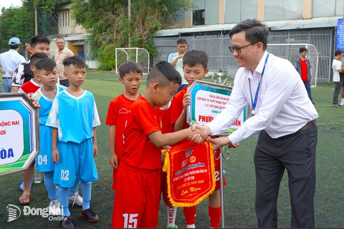 Ông Phạm Thái Thuận, Chánh Văn phòng Báo và Phát thanh, Truyền hình Đồng Nai tặng cờ lưu niệm cho các đội bóng. Ảnh: An Nhơn