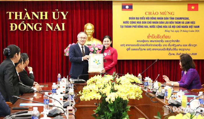 Đồng chí Phonsy Bounmixay, Tổng Lãnh sự nước Cộng hòa Dân chủ Nhân dân Lào tại Thành phố Hồ Chí Minh trao quà cho lãnh đạo thành phố Đồng Nai. Ảnh: Hồ Thảo