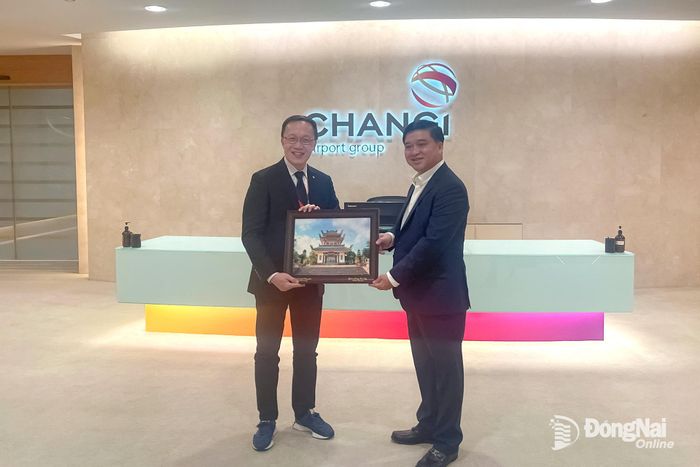 Thành ủy viên, Phó Chủ tịch UBND thành phố Đồng Nai Hồ Văn Hà và ông Yim Kein Fai Dennis, Phó Chủ tịch, phụ trách truyền thông Marketking và hợp tác Tập đoàn Sân bay Changi tặng quà lưu niệm.