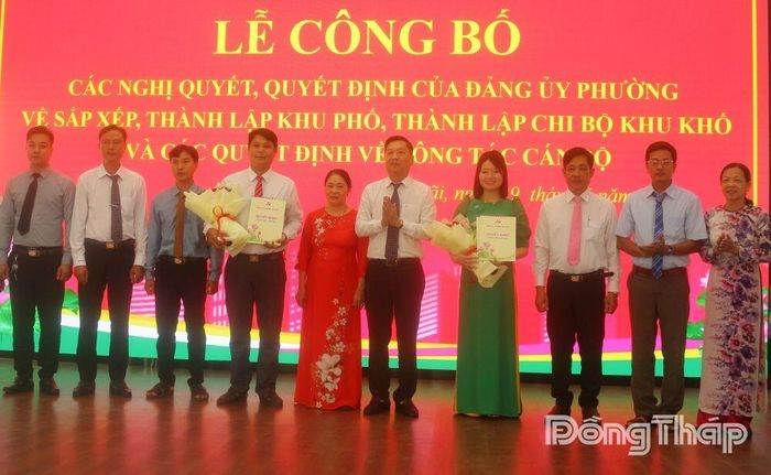 Đồng chí Nguyễn Ngọc Luân Lý, Phó Bí thư Thường trực Đảng ủy phường Mỹ Ngãi (thứ 5 từ phải sang) trao Quyết định về thành lập Chi ủy, Bí thư Chi bộ khu phố. Ảnh: PHƯƠNG NGA