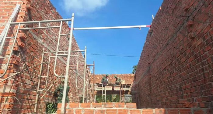  Cán bộ, chiến sĩ Đại đội 17 giúp xây nhà cho gia đình ông Nguyễn Văn Tân. Ảnh: N.T 