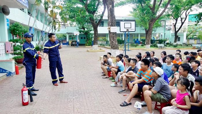  Cán bộ Phòng Cảnh sát PCCC và CNCH (Công an tỉnh Gia Lai) hướng dẫn thiếu nhi kỹ năng sử dụng bình chữa cháy mini. Ảnh: D.L 