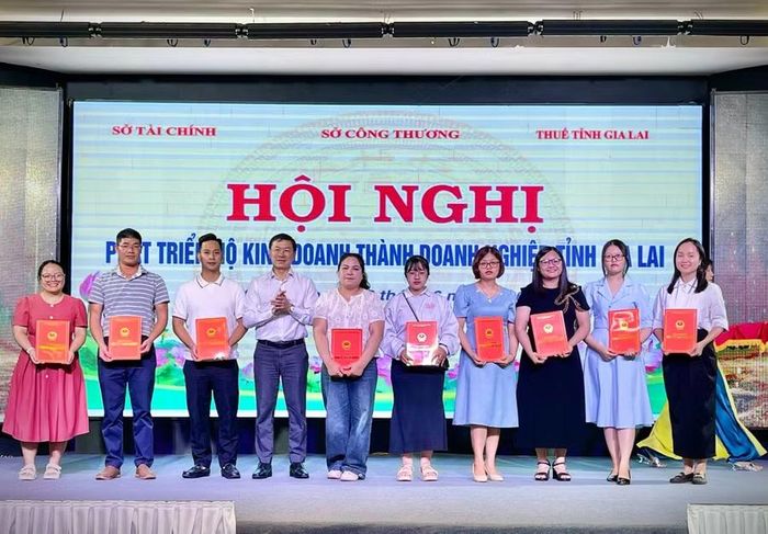  Đại diện lãnh đạo Sở Tài chính trao giấy chứng nhận đăng ký doanh nghiệp cho các hộ kinh doanh chuyển đổi lên doanh nghiệp. Ảnh: Minh Phương 