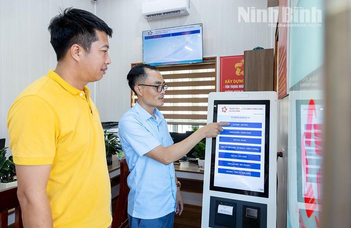 Cán bộ xã Phú Long tận tình hướng dẫn người dân tra cứu thông tin, nộp hồ sơ trên hệ thống ki-ốt điện tử.