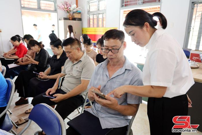 Người dân bản Mé Ban, phường Chiềng Cơi sử dụng điện thoại thông minh truy cập các ứng dụng số.