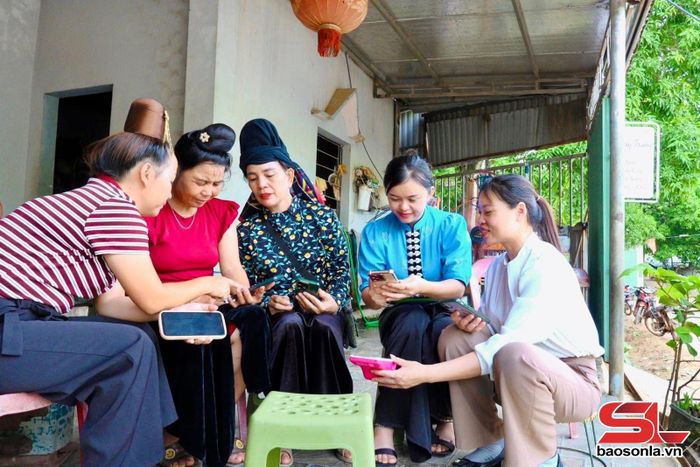 Thành viên Tổ Công nghệ số cộng đồng bản Khoa, xã Tạ Khoa, hướng dẫn hội viên phụ nữ sử dụng các tiện tích số.
