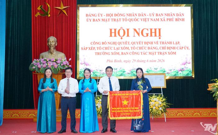 Đồng chí Nguyễn Thị Loan trao Cờ đơn vị dẫn đầu phong trào thi đua năm 2025 của UBND tỉnh tặng Nhân dân và Đảng bộ xã Phú Bình.