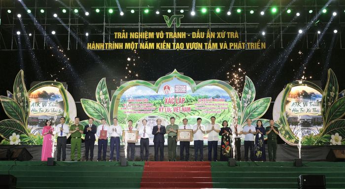 Trao Quyết định công nhận hai Kỷ lục cho xã Vô Tranh, gồm: Màn trình diễn múa Tắc xình kết hợp tạo hình hoa trà và vòng tròn đoàn kết; xếp mô hình ấm trà trên đồi trà. Ảnh: Đồng Văn Thưởng