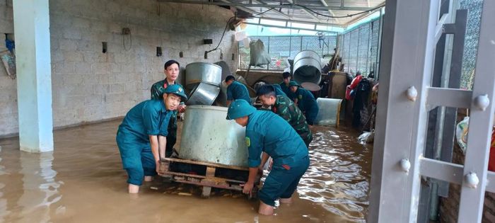 Lực lượng chức năng xã Trà Lĩnh hỗ trợ người dân di dời tài sản.