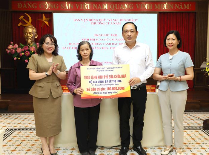 Ban vận động Quỹ "Vì người nghèo" phường Cửa Nam trao biển hỗ trợ sửa nhà cho gia đình bà Lê Thị Hoa (phố Tràng Tiền) trị giá 100 triệu đồng. Ảnh: PV