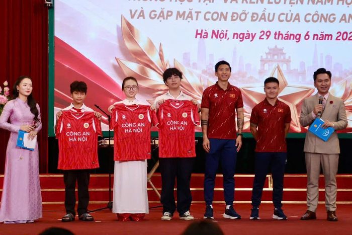 Cầu thủ của CLB Công an Hà Nội do tiền vệ Quang Hải và hậu vệ Đoàn Văn Hậu trao tặng áo cho các em học sinh. Ảnh: PV