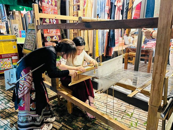 Du khách trải nghiệm dệt thủ công. Ảnh: Hoàng Quyên