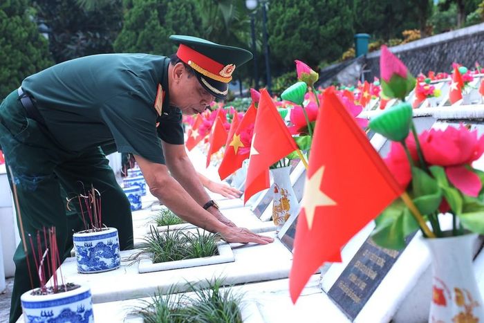 Cựu chiến binh lặng lẽ đặt tay lên bia mộ đồng đội tại Nghĩa trang Liệt sĩ Quốc gia Vị Xuyên, tỉnh Tuyên Quang