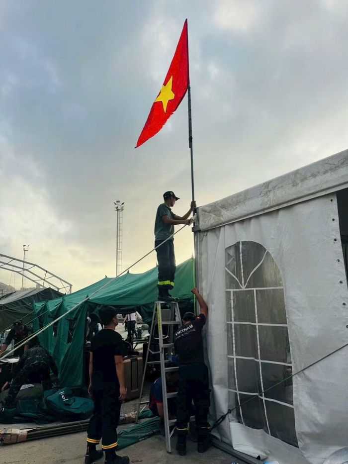 Chiến sĩ Việt Nam cắm cờ lập trại triển khai công tác cứu nạn, cứu hộ tại nước bạn.