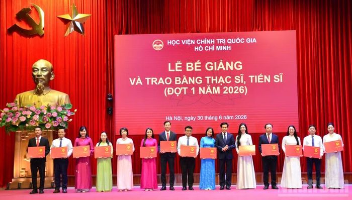 Đồng chí Hoàng Phúc Lâm, Phó Bí thư Đảng ủy, Phó Giám đốc Học viện Chính trị quốc gia Hồ Chí Minh trao bằng tiến sĩ cho các học viên. (Ảnh: PHẠM CƯỜNG)