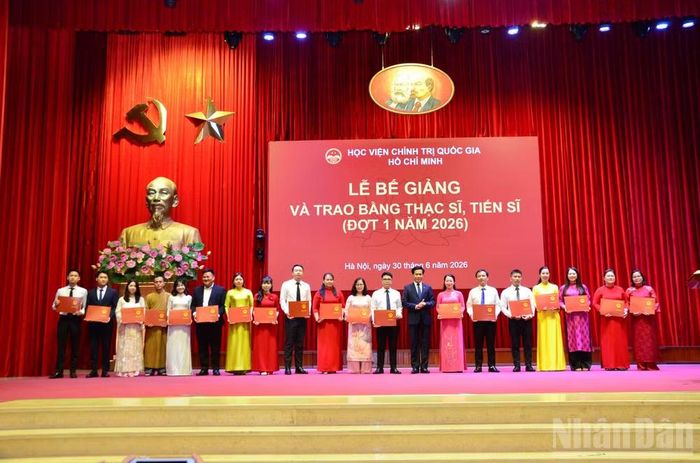 Đồng chí Hoàng Phúc Lâm, Phó Bí thư Đảng ủy, Phó Giám đốc Học viện Chính trị quốc gia Hồ Chí Minh trao bằng thạc sĩ cho các học viên. (Ảnh: PHẠM CƯỜNG)