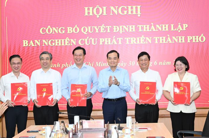  Đồng chí Trần Lưu Quang trao quyết định đến các đồng chí Phó Trưởng Ban Nghiên cứu phát triển TPHCM. Ảnh: VIỆT DŨNG 