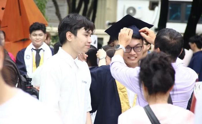Phụ huynh chỉnh trang, chăm sóc cho con trong ngày nhận bằng tốt nghiệp,