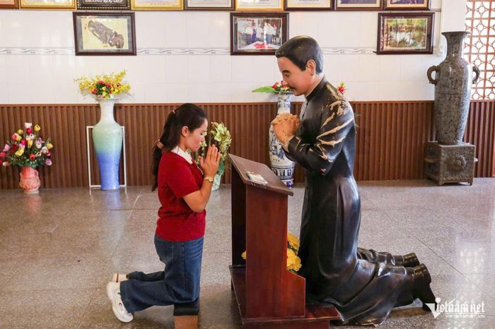 Một người hành hương cầu nguyện trước tượng linh mục Trương Bửu Diệp. Ảnh: Tào Đạt