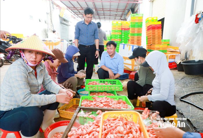 Cán bộ phường Quỳnh Mai trao đổi, nắm bắt tình hình chế biến các sản phẩm thủy sản của người dân. Ảnh: Thành Duy