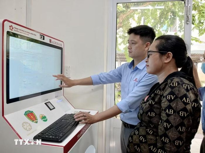 Hướng dẫn người dân thực hiện làm thủ tục hành chính trên kios hành chính công thông minh tại Trung tâm phục vụ hành chính công phường Ngũ Hành Sơn, thành phố Đà Nẵng. (Ảnh: Mỹ Hà/TTXVN)