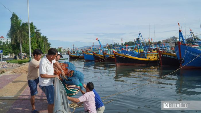 Những ngư dân đưa ngư lưới cụ xuống tàu để chuẩn bị ra khơi.