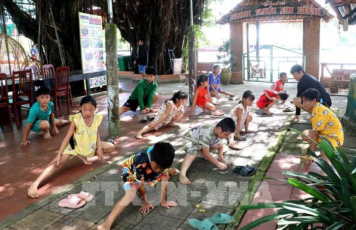 Trẻ em xã An Bình (Vĩnh Long) tập khởi động trong giờ học bơi miễn phí. Ảnh: Lê Thúy Hằng – TTXVN