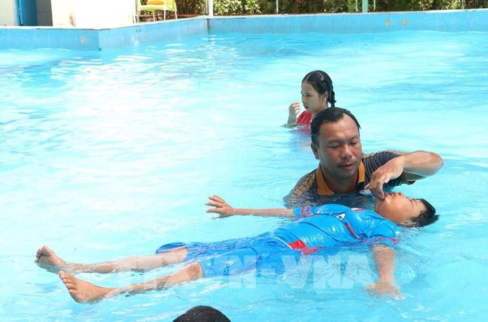 Giáo viên hướng dẫn các kỹ thuật nổi nước cho trẻ. Ảnh: Lê Thúy Hằng – TTXVN