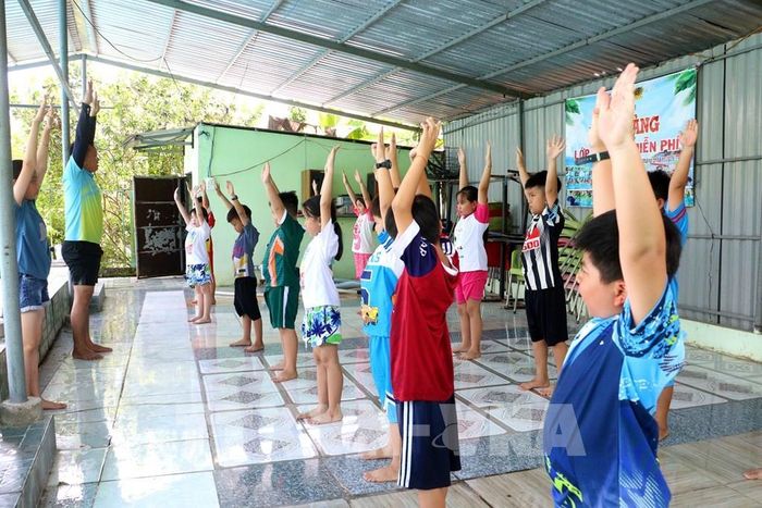 Trẻ em xã Hòa Bình (Vĩnh Long) tập khởi động trong giờ học bơi miễn phí. Ảnh: Lê Thúy Hằng – TTXVN