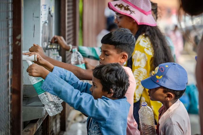Trẻ em lấy nước uống từ vòi nước công cộng trong một ngày nắng nóng.