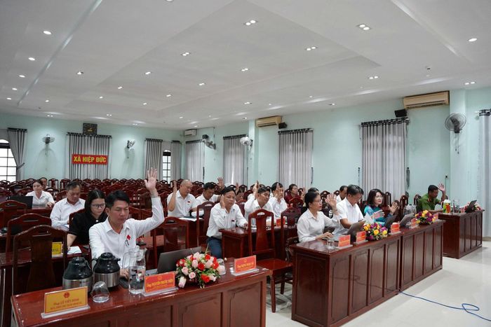 Đại biểu HĐND xã Hiệp Đức biểu quyết thông qua nghị quyết kỳ họp. Ảnh: GIA PHÚC