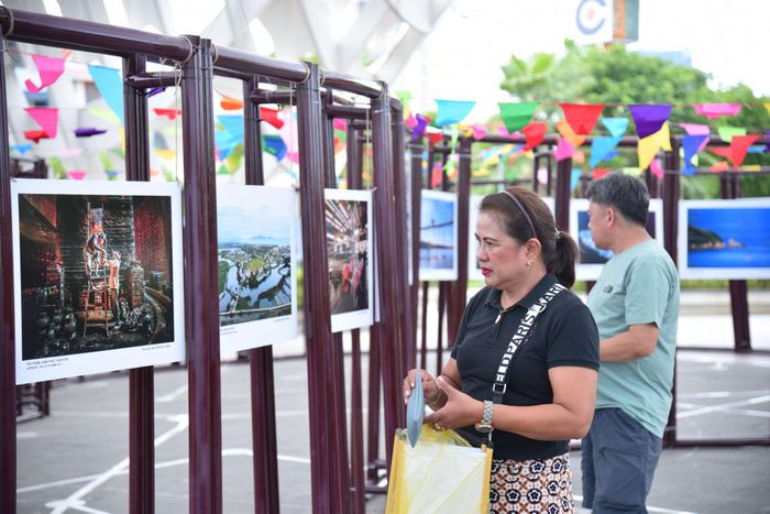 Du khách tham quan không gian trưng bày ảnh về bối cảnh quay phim tại Công viên APEC. Ảnh: NGUYÊN HẢI