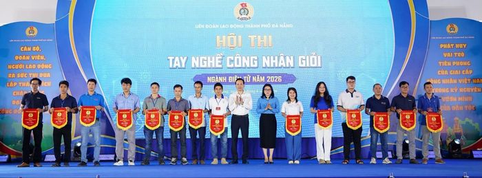 Bà Phan Thị Thúy Linh, Chủ tịch Liên đoàn Lao động thành phố Đà Nẵng (thứ 8, bên phải sang) trao cờ luân lưu cho các đơn vị tham gia Hội thi tay nghề công nhân giỏi - một trong những hoạt động đồng hành thiết thực cùng doanh nghiệp và người lao động. Ảnh: LĐLĐ ĐÀ NẴNG