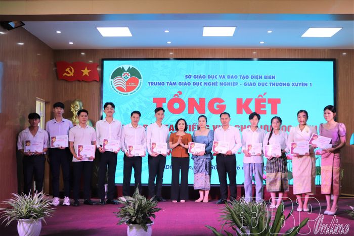 Bà Phạm Thúy, Giám đốc Trung tâm Giáo dục nghề nghiệp - Giáo dục thường xuyên 1 tặng Giấy khen cho các lưu học sinh Lào có thành tích học tập xuất sắc.