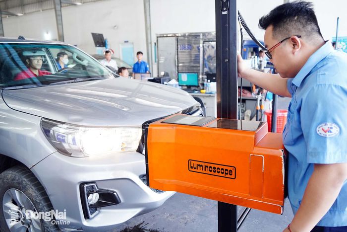 Đăng kiểm viên Trung tâm Đăng kiểm xe cơ giới 60-04D (phường Long Bình) thực hiện kiểm tra hệ thống đèn chiếu sáng của phương tiện theo quy trình đăng kiểm. Ảnh: Lê Duy