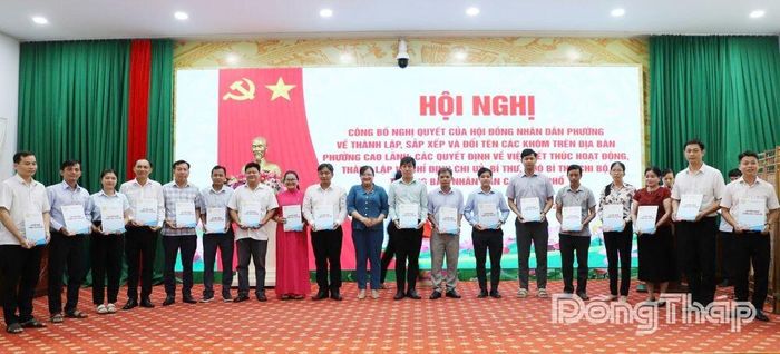 Phó Chủ tịch UBND phường Cao Lãnh Hồ Huệ Thu Hằng (thứ 10 từ trái sang) trao Quyết định.