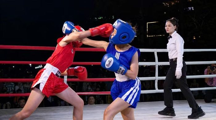  Màn đối đầu kịch tính giữa võ sĩ Đỗ Ngọc Anh (găng đỏ, xã Chư Sê) và Lâm Hồng Ánh (phường Bồng Sơn) tại chương trình Đại hội TDTT môn boxing tỉnh Gia Lai. Ảnh: H.V 
