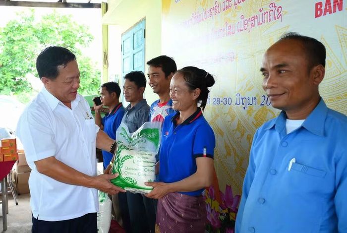  Trung tá Nguyễn Tất Dần - Phó Giám đốc Công ty Hợp tác kinh tế 385 tặng quà cho người lao động và nhân dân Lào. Ảnh: Đình Khoa 