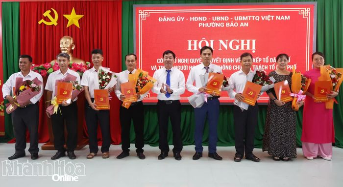 Lãnh đạo Đảng ủy phường Bảo An trao quyết định và tặng hoa chúc mừng các chi bộ tổ dân phố mới. 