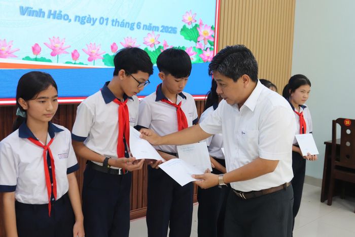 Ông Trần Ngọc Hưởng, Phó Giám đốc, Chủ tịch Công đoàn NMNĐ Vĩnh Tân 4 trao học bổng cho học sinh xã Vĩnh Hảo