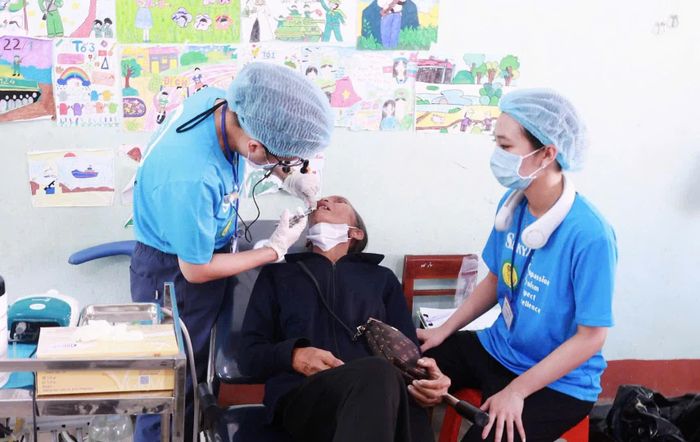 Bác sĩ nha khoa đến từ Bệnh viện Trung ương Huế khám răng cho một bệnh nhân cao tuổi ở xã Hướng Hiệp - Ảnh: K.S