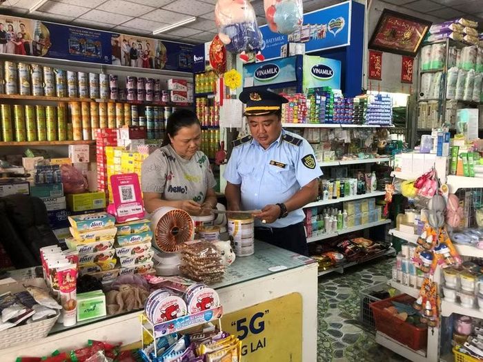  Công chức Quản lý thị trường phát tờ gấp “Một số quy định của pháp luật về an toàn thực phẩm” cho các hộ kinh doanh. 