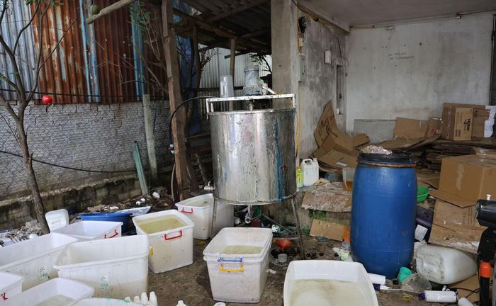Máy trộn hóa chất và các thùng nhựa chứa hóa chất đã pha trộn để chiết rót vào các chai sữa tắm giả.