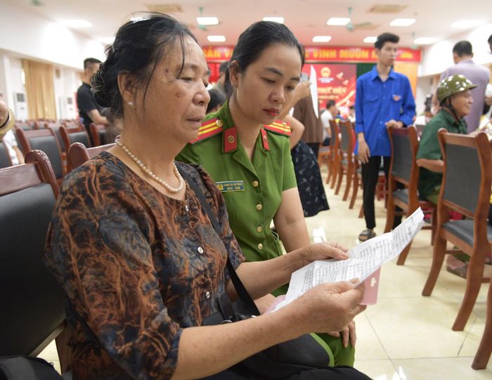 Bà Đỗ Thị Thìn mở lá thư của anh trai liệt sĩ Đỗ Trọng Lung gửi về cho gia đình.
