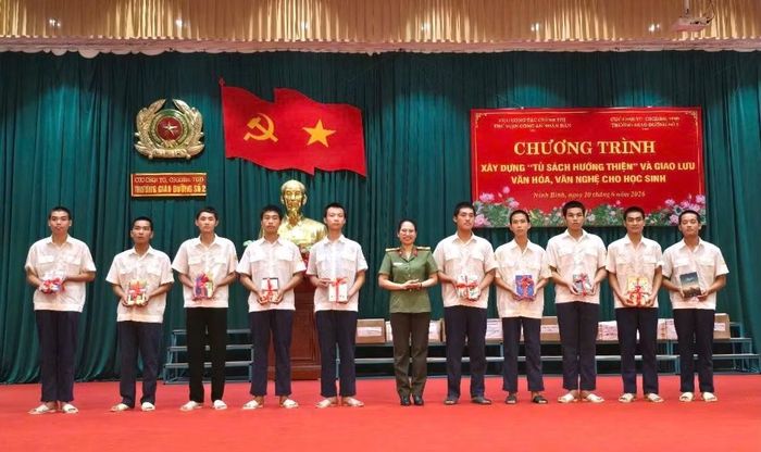 Trung tá Đỗ Thu Thơm, Giám đốc Thư viện CAND trao tặng sách cho các em học sinh.
