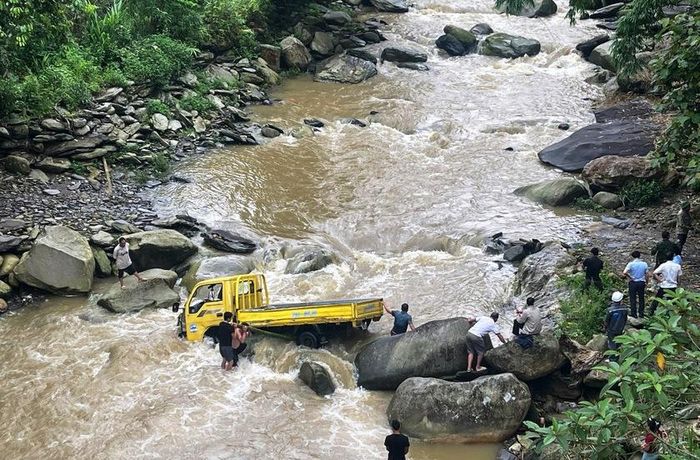 Chiếc xe tải đi qua ngầm bị lũ cuốn trôi, mắc kẹt giữa dòng nước lũ đang dâng cao. Ảnh: Công an xã Ngũ Chỉ Sơn